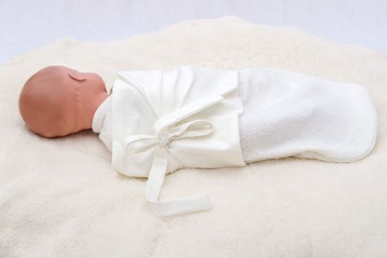 Baby mit Puckband auf Liegesack sicher und stabil lagern sichere Lagerung von Babys mit Puck Wickelband auf Babyliegekissen mit Baumwoll Decke